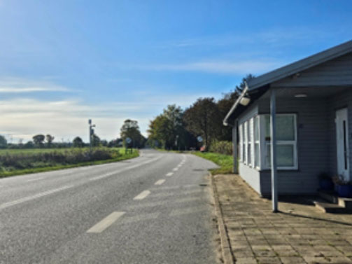 Foto von einem kleinen grauen Haus neben einer unbefahrenen Straße